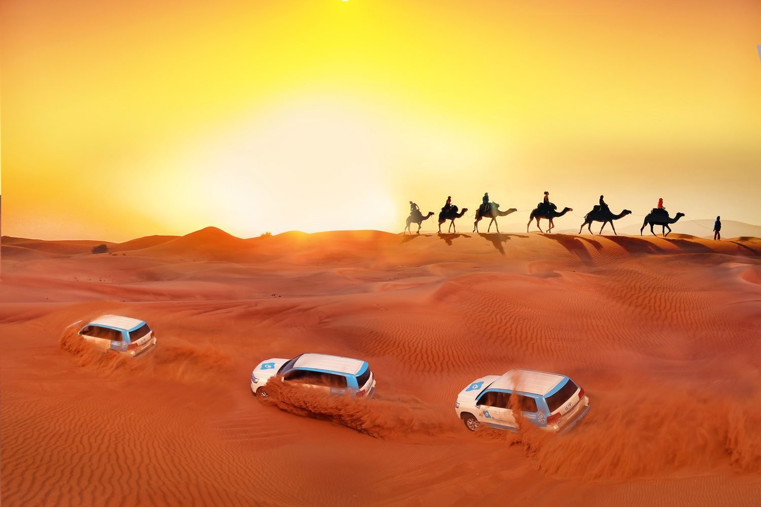 A 4x4 crossing red sand dunes at sunset on a desert safari in Dubai